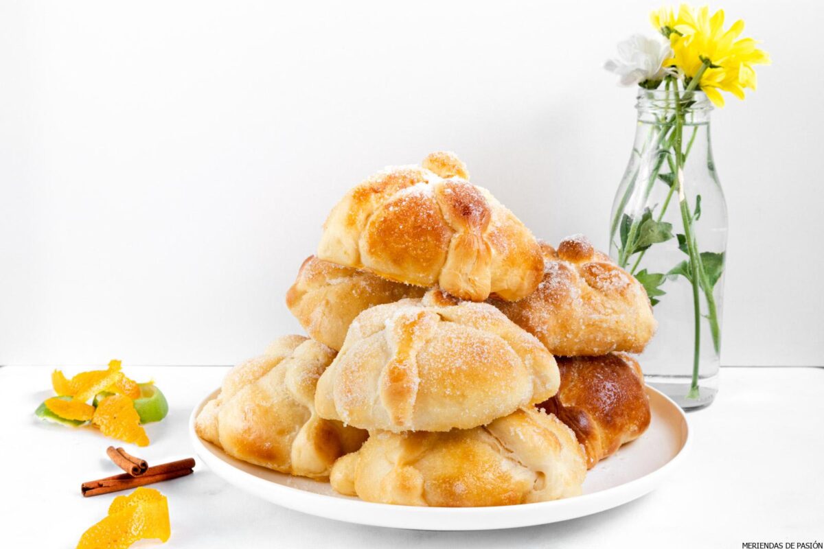 Day of the Dead Breads on a white plate and a small jar of flowers