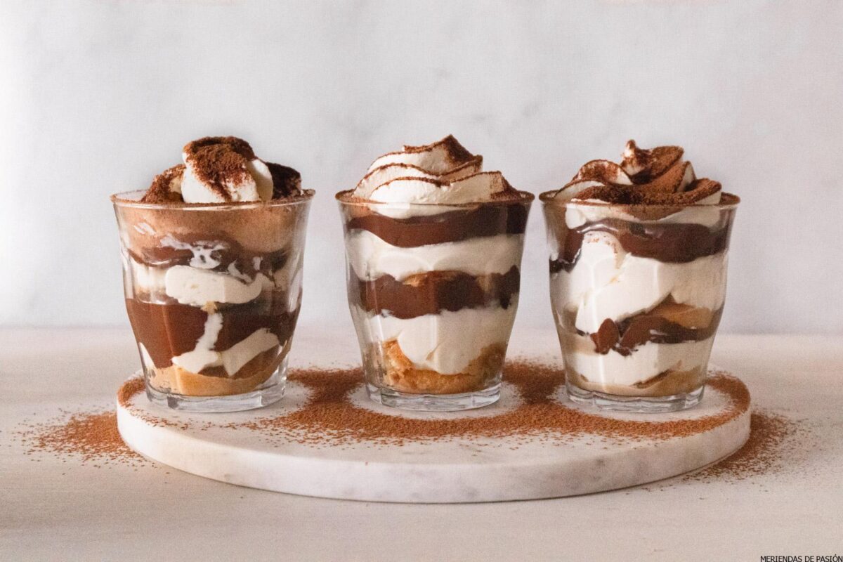 We see three small homemade tiramisu cups without eggs and with Nutella, covered in cocoa.
