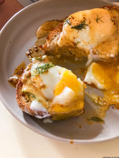 Un plato de tostadas con huevos y eneldo.