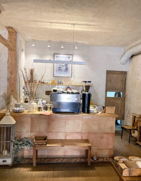 El interior de una cafetería con mesas y sillas de madera.