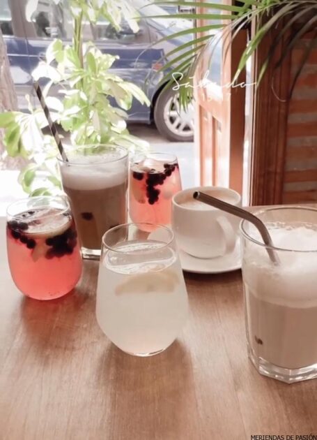 Un grupo de bebidas sobre una mesa con una pajita.