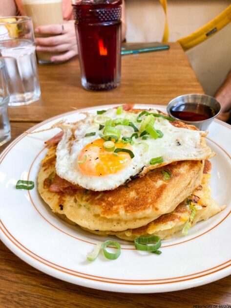 Un plato de tortitas con un huevo encima.