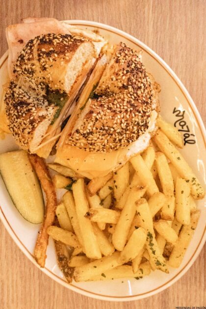 Un sándwich de bagel con patatas fritas y patatas fritas en un plato.