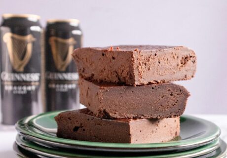 Una pila de dulce de chocolate en un plato junto a una lata de Guinness.