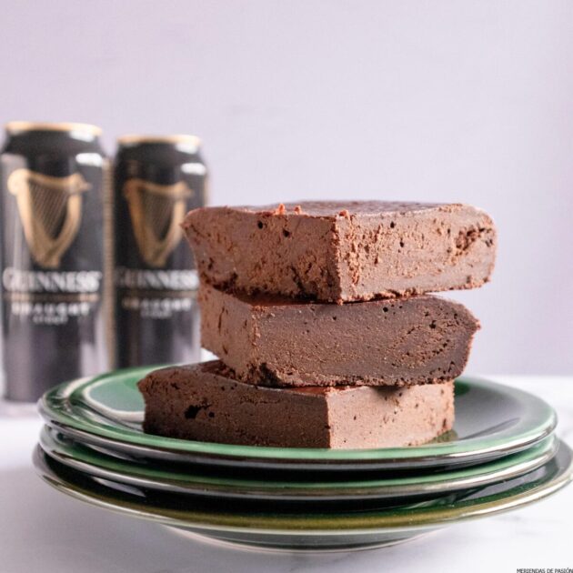 Una pila de dulce de chocolate en un plato junto a una lata de Guinness.