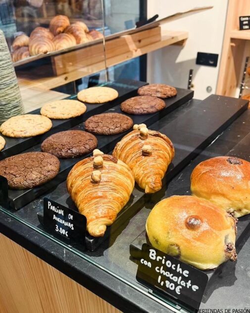 Pasteles variados, incluidos croissants y brioche, expuestos en una panadería.
